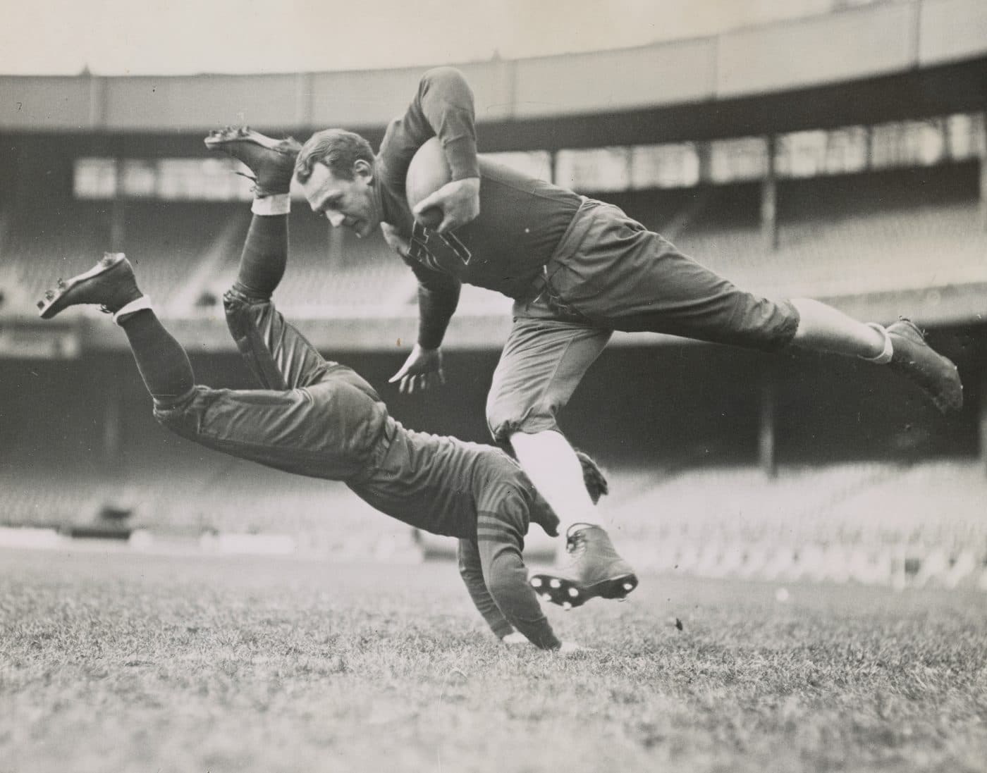 Deux joueurs de rugby en plein plaquage sur un terrain, photographie ancienne en noir et blanc